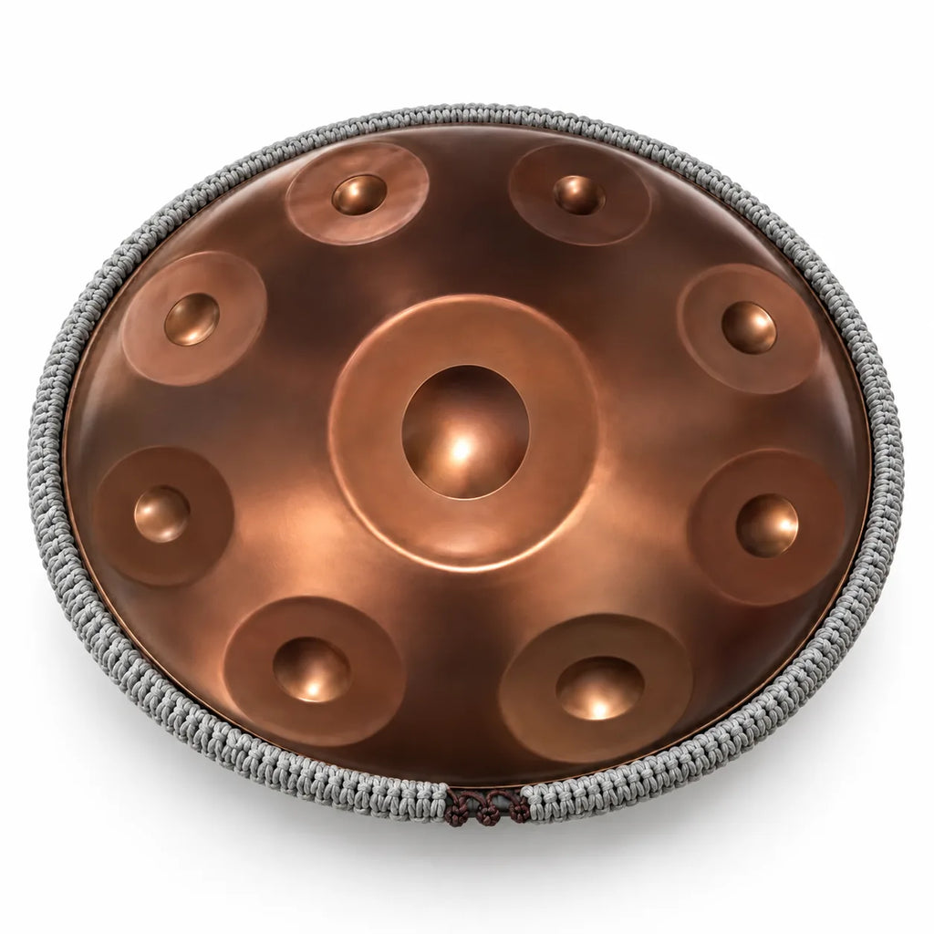 Cordon de protection tressé gris fixé autour d'un handpan bronze, sur fond blanc