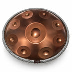 Cordon de protection tressé gris fixé autour d'un handpan bronze, sur fond blanc