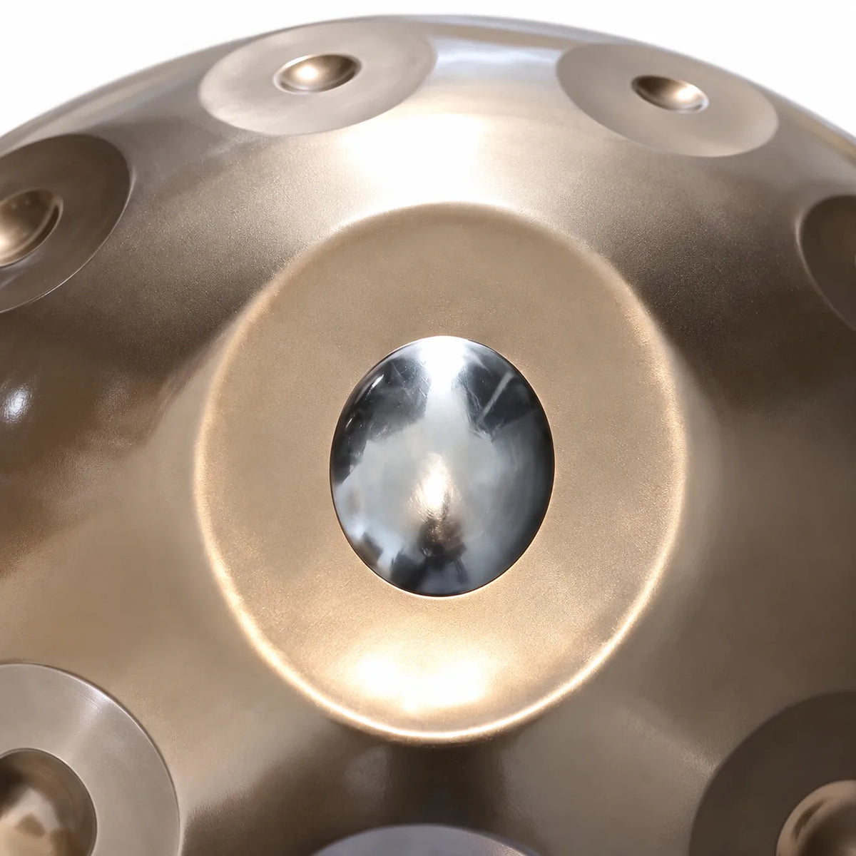 Gros plan sur la note centrale en inox poli d'un handpan D Kurd argenté façonné main
