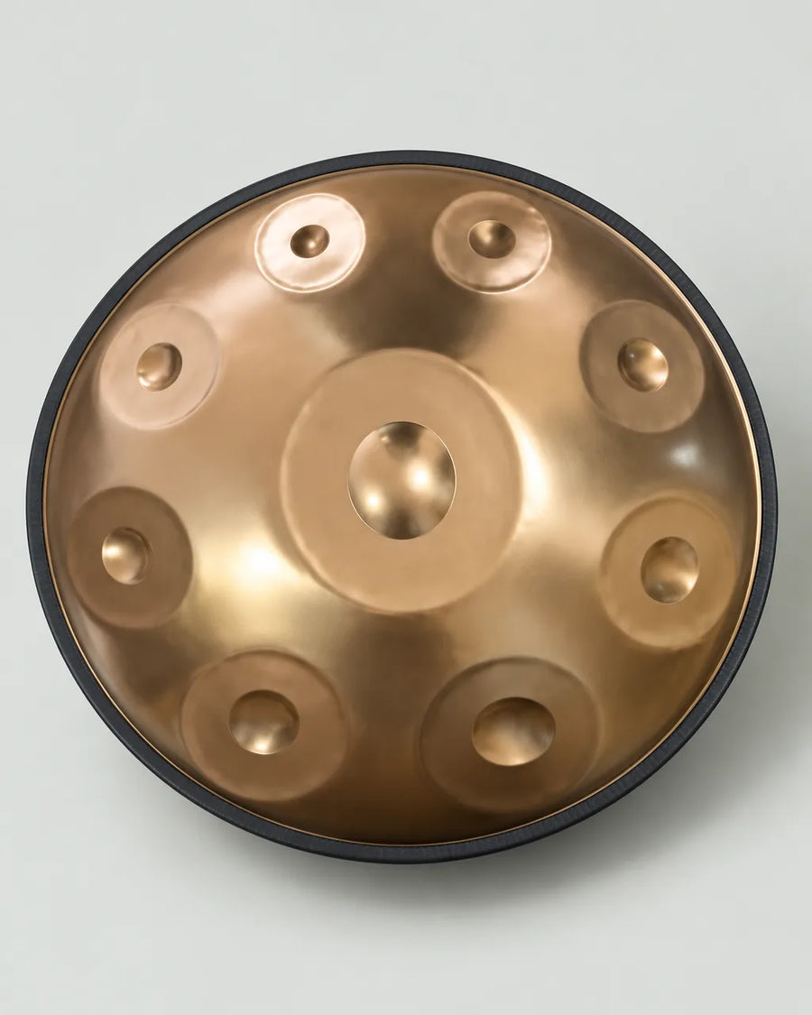 Handpan D Kurd doré en inox sur fond gris clair
