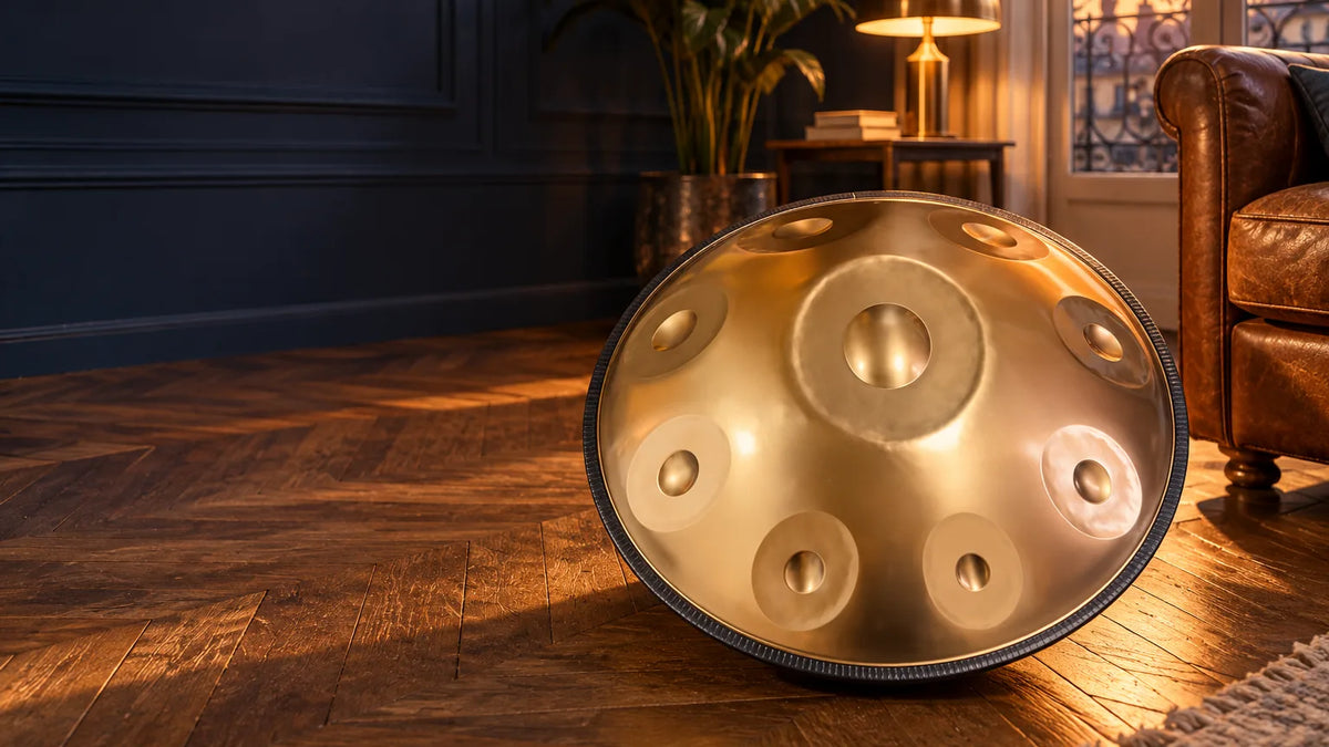 Handpan doré posé sur un parquet en point de Hongrie, dans un salon parisien au coucher du soleil