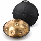 Housse rigide noire posée derrière un handpan doré : elle est à sa taille